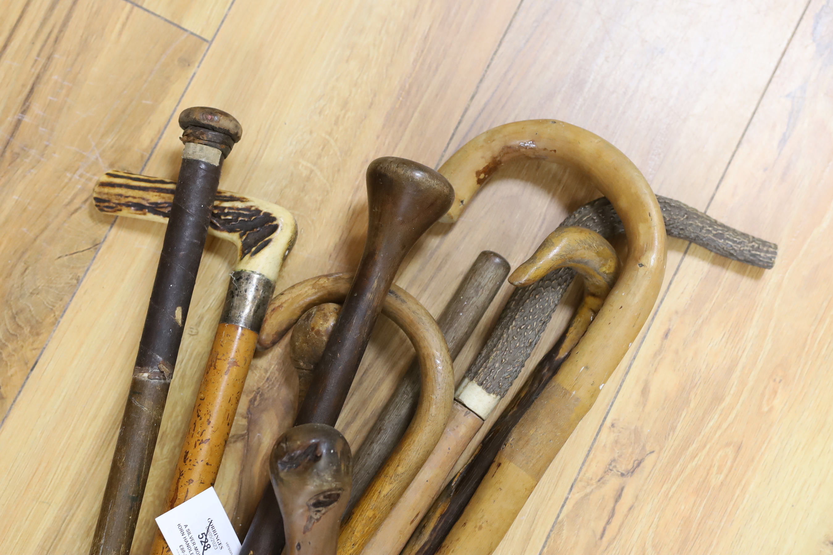 A silver-mounted horn handled malacca walking stick and nine others